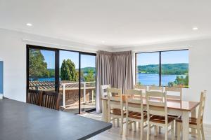 a dining room with a table and a view of the water at Forsters Bay Haven in Narooma