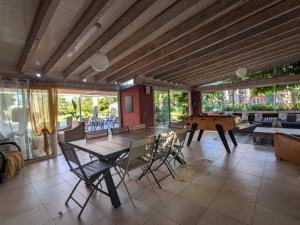 a dining room with a table and a pool table at Gite L olivier in Baho