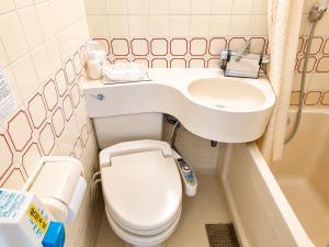 a small bathroom with a toilet and a sink at 和洲館ホテル in Gyōda