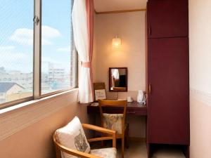 a room with a desk and a window at 和洲館ホテル in Gyōda