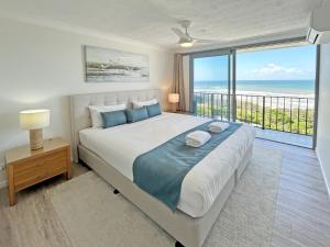 a bedroom with a large bed with a view of the ocean at Majorca Isle Beachside Resort in Maroochydore +176 photos
