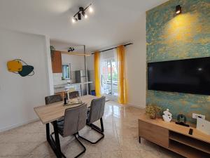 a dining room with a table and a large screen tv at Holiday home Tcono in Tkon