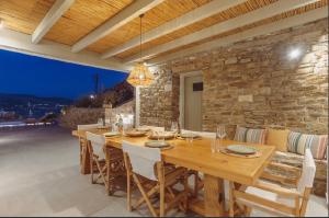 a dining room with a wooden table and chairs at Morning glow villa in Antiparos