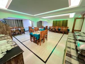 a restaurant with tables and chairs in a room at Hotel Om Ladakh in Leh