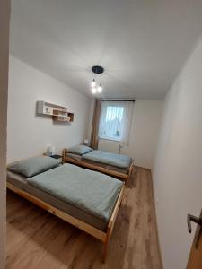 two beds in a room with a window at Penzión Ostrva in Vyšné Hágy