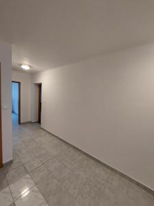 an empty room with a white wall and a tile floor at Penzión Ostrva in Vyšné Hágy