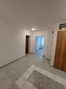 an empty room with white walls and tile floors at Penzión Ostrva in Vyšné Hágy +59 photos