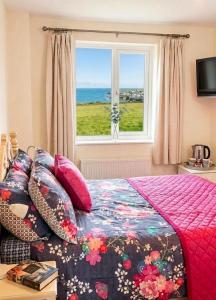 a bedroom with a bed with a view of the ocean at Halekulani Devon Homestay in Torquay