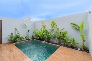 a swimming pool in a room with plants at Iris Apartment in Dalung