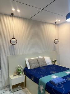 a bedroom with a bed with blue sheets and white pillows at Casa résidences in Bouaké