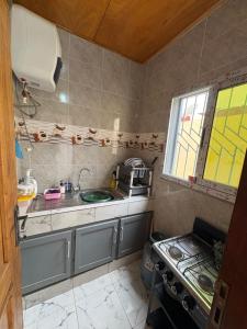a small kitchen with a sink and a stove at Casa résidences in Bouaké