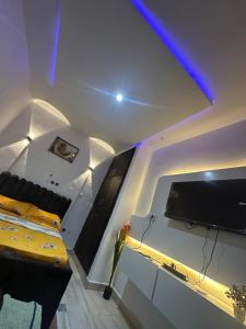 a living room with a couch and a tv on the wall at Casa résidences in Bouaké