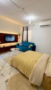 a bedroom with a blue bed and a couch at Casa résidences in Bouaké