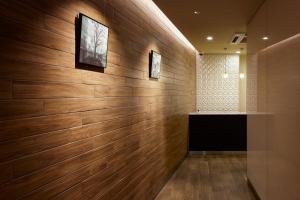 a room with a wooden wall with a television at KARIO Sasazuka in Tokyo +2 photos