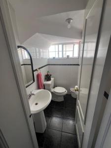 a small bathroom with two toilets and a sink at House in a private gated community in Chihuahua