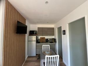 a small kitchen with a table and a refrigerator at Jazz in Vallauris +3 photos