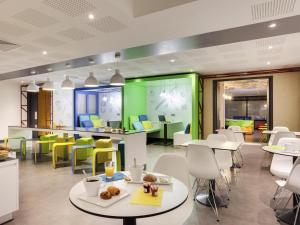 a restaurant with white tables and yellow chairs at ibis Styles Nantes Centre Gare in Nantes