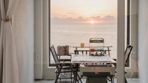 a table and chairs with a view of the ocean at Pohang Pine Wave Pension in Pohang +1 photo