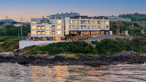 a large building on a hill next to the water at Pohang Pine Wave Pension in Pohang
