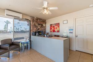 a bar in a room with chairs and a ceiling fan at Budgetel Inn & Suites in Yuma