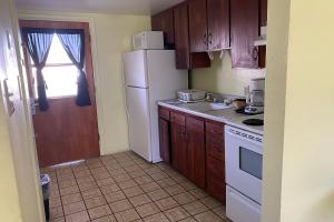 a kitchen with wooden cabinets and a white refrigerator at Budgetel Inn & Suites in Yuma