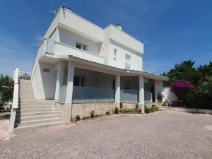 a white house with stairs and flowers in front of it at L'Acquaviva in Bisceglie