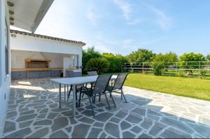 a patio with a table and chairs in a yard at Green Galini Villa Pelion - the small unit in Platanidia