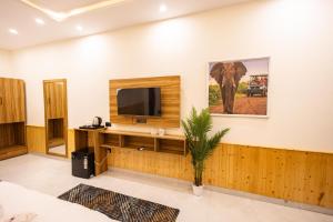 a living room with a television and an elephant on the wall at Tiger Aura Resort in Rāmnagar