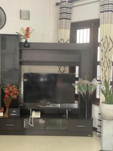a black entertainment center with a flat screen tv at Chrish Residence in Negombo