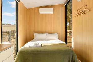 a small bedroom with a bed and a window at Kookaburra Retreat by Tiny Away in Arcadia