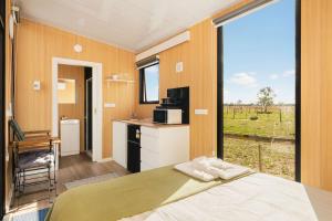 a room with a bed and a large window at Kookaburra Retreat by Tiny Away in Arcadia