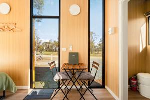 a room with a table with chairs and a laptop on it at Kookaburra Retreat by Tiny Away in Arcadia