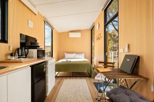 a small room with a bed and a kitchen at Kookaburra Retreat by Tiny Away in Arcadia +14 photos