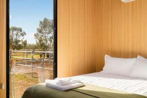 a bedroom with a bed and a window with a view at Kookaburra Retreat by Tiny Away in Arcadia