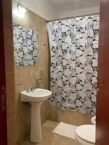 a bathroom with a sink and a shower curtain at Benitez Hostería in Calilegua +64 photos