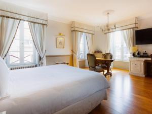 a bedroom with a large white bed and a desk at Mercure Moulins Centre Hôtel de Paris in Moulins +91 photos