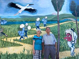 a man and a woman standing in front of a painting at Hall D - Vacation STAY 14820 in Kōnosu