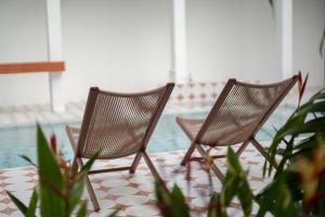 two chairs sitting next to a swimming pool at Baan Old Town Boutique Stay, Phuket Town in Phuket