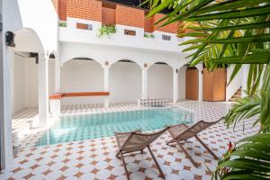 a pool in the middle of a house with two chairs at Baan Old Town Boutique Stay, Phuket Town in Phuket +31 photos