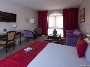 a hotel room with a bed and a living room at Mercure Cayenne Royal Amazonia in Cayenne +111 photos