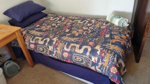 a bed with a colorful comforter on top of it at Highway Haven in Stilfontein +10 photos