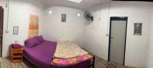 a bedroom with a purple bed in a room at โบว์ ปางอุ๋ง in Ban Huai Makhuea Som