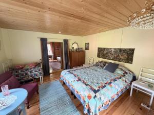 ein Schlafzimmer mit einem Bett und einer Holzdecke in der Unterkunft Metsäpirtti in Kolinkylä