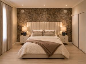 a bedroom with a large bed with two night stands at The Luxury Orchid in Pietermaritzburg +9 photos