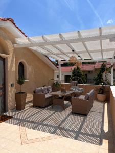 a patio with couches and a table on a building at GREEN and BLUE VILLA in Glykadi