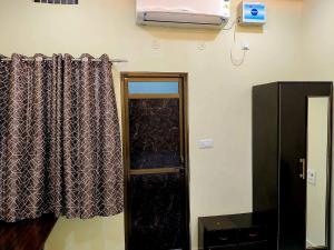 a room with a door and a window with a curtain at Hotel Ram Shankar - Saryu Ghat in Ayodhya