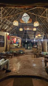 a room with tables and chandeliers on the ceiling at Evergreen Bungalows in Bwejuu