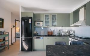 a kitchen with a refrigerator in the middle of it at Vigla View Sifnos in Vathi