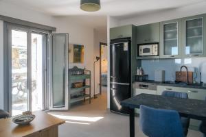a kitchen with a refrigerator and a table with chairs at Vigla View Sifnos in Vathi +23 photos