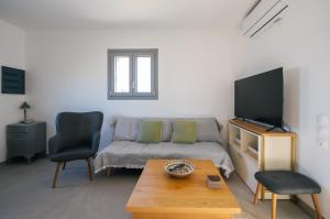 a living room with a couch and a tv at Vigla View Sifnos in Vathi